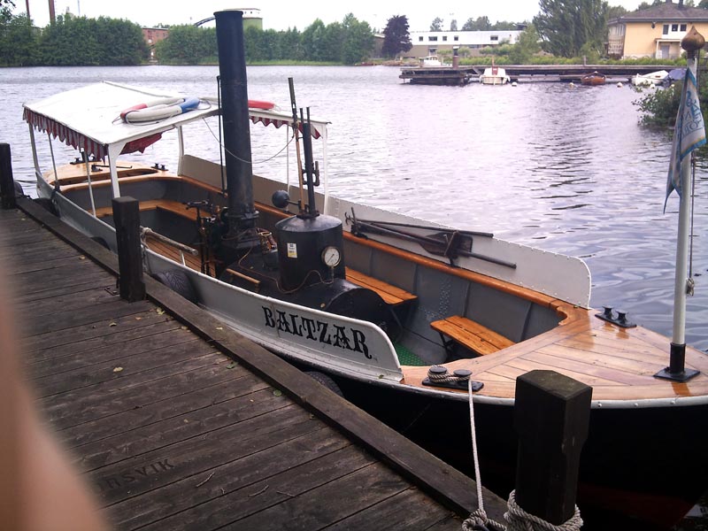 med liten ångbåt i drift